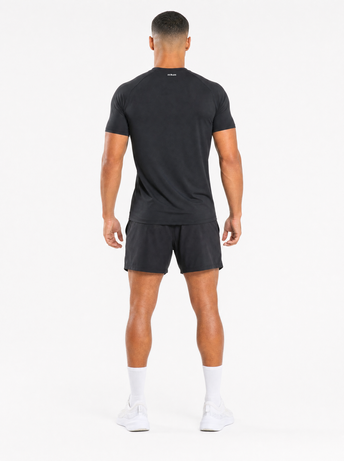 FIT APE Performance Tee in black, worn by male fitness model, back view with FIT APE logo below the collar