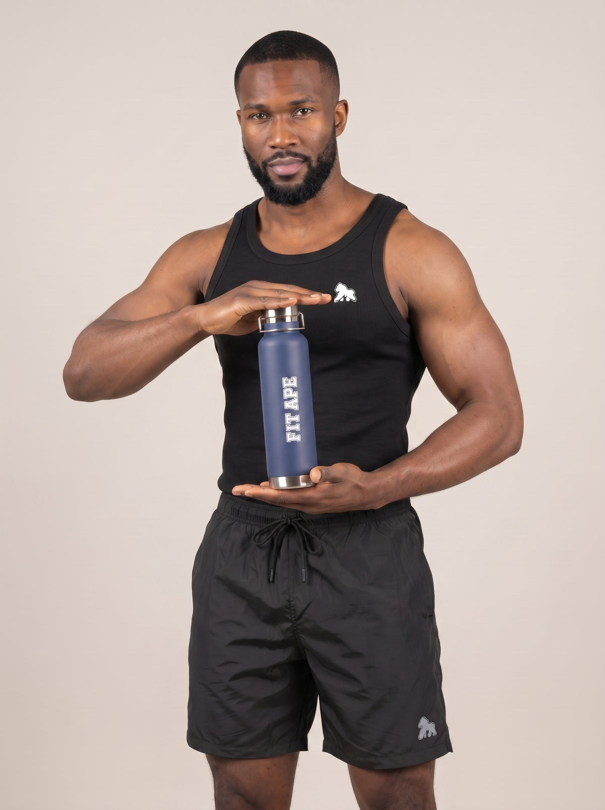 Model in black gym clothing holding a navy FIT APE water bottle in front
