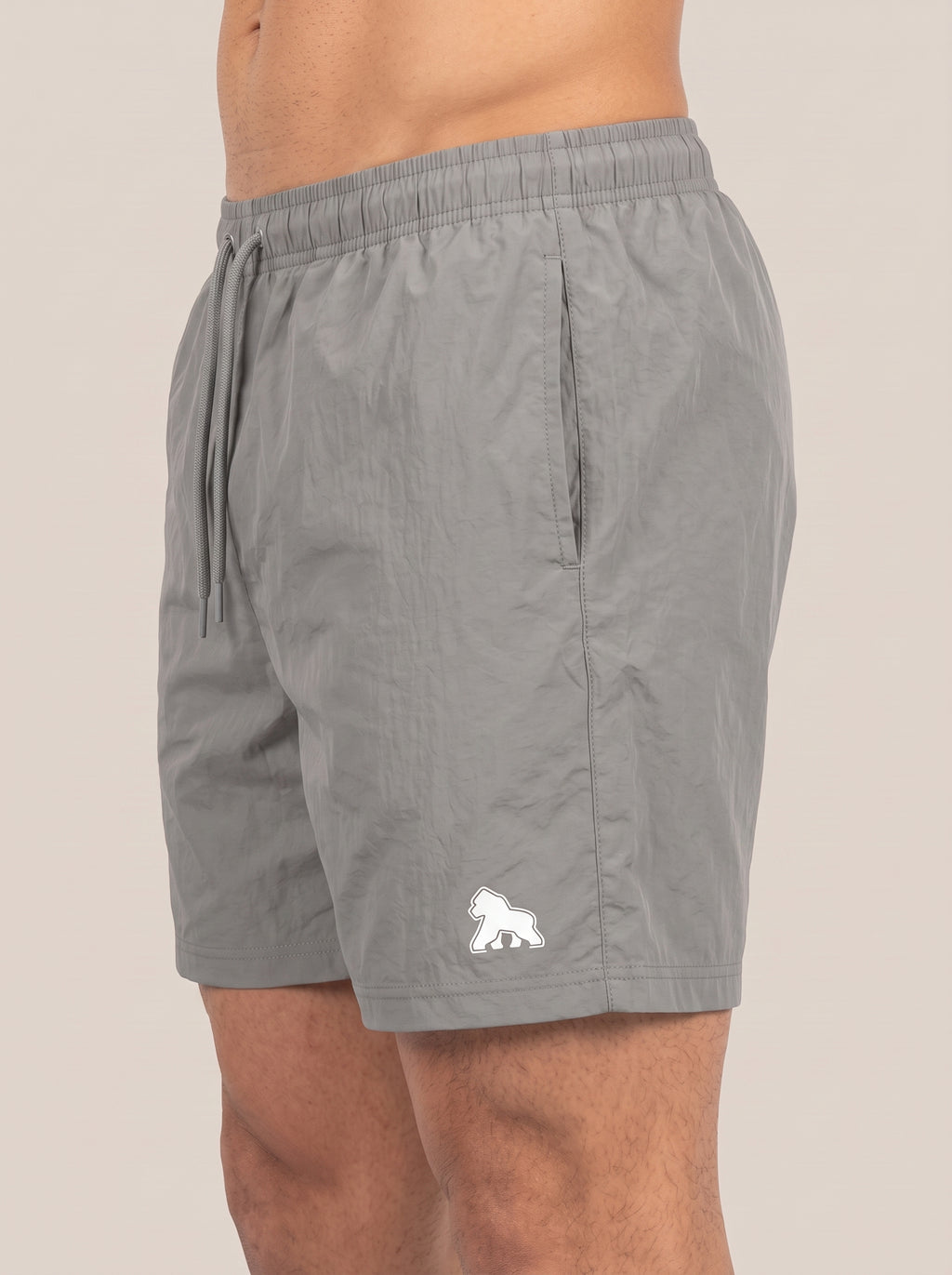 Gray FIT APE men's performance shorts on a model, angled side view