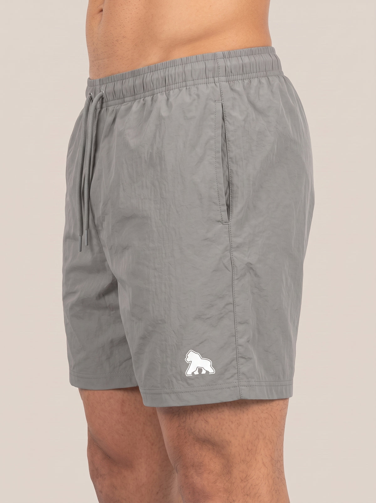 Gray FIT APE men's performance shorts on a model, angled side view