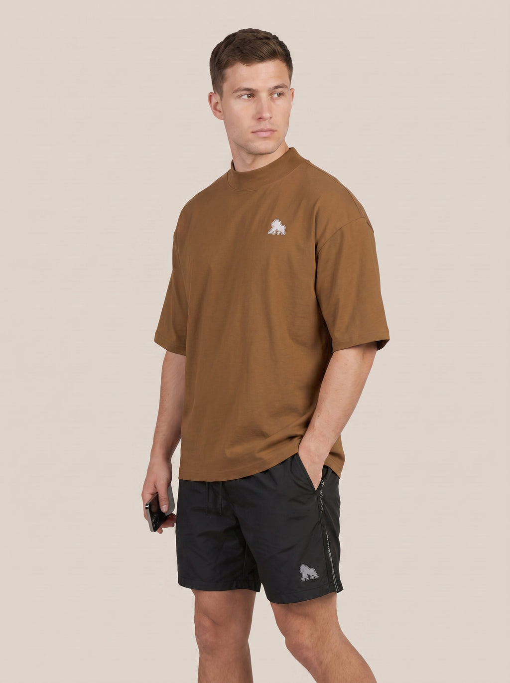 Brown FIT APE men's oversized tee on a model, side three-quarter view