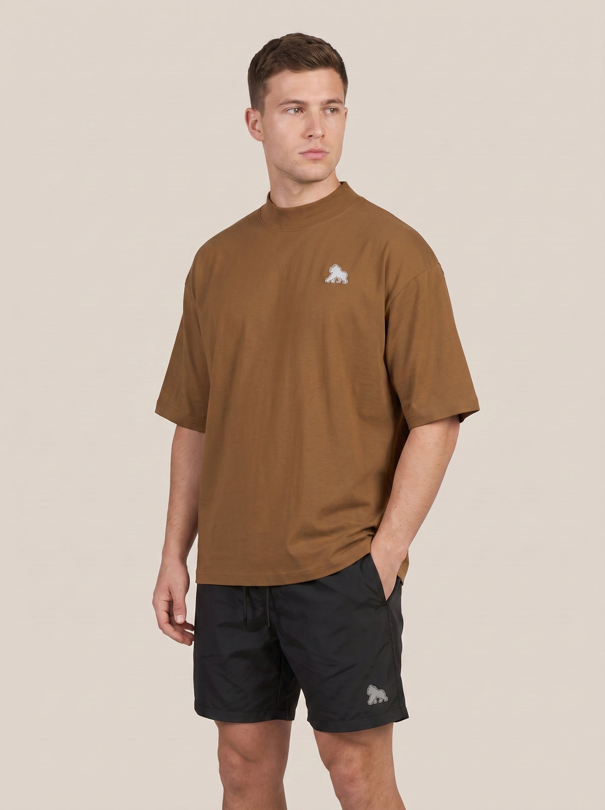 Brown FIT APE men's oversized tee on a model with one hand in his pocket