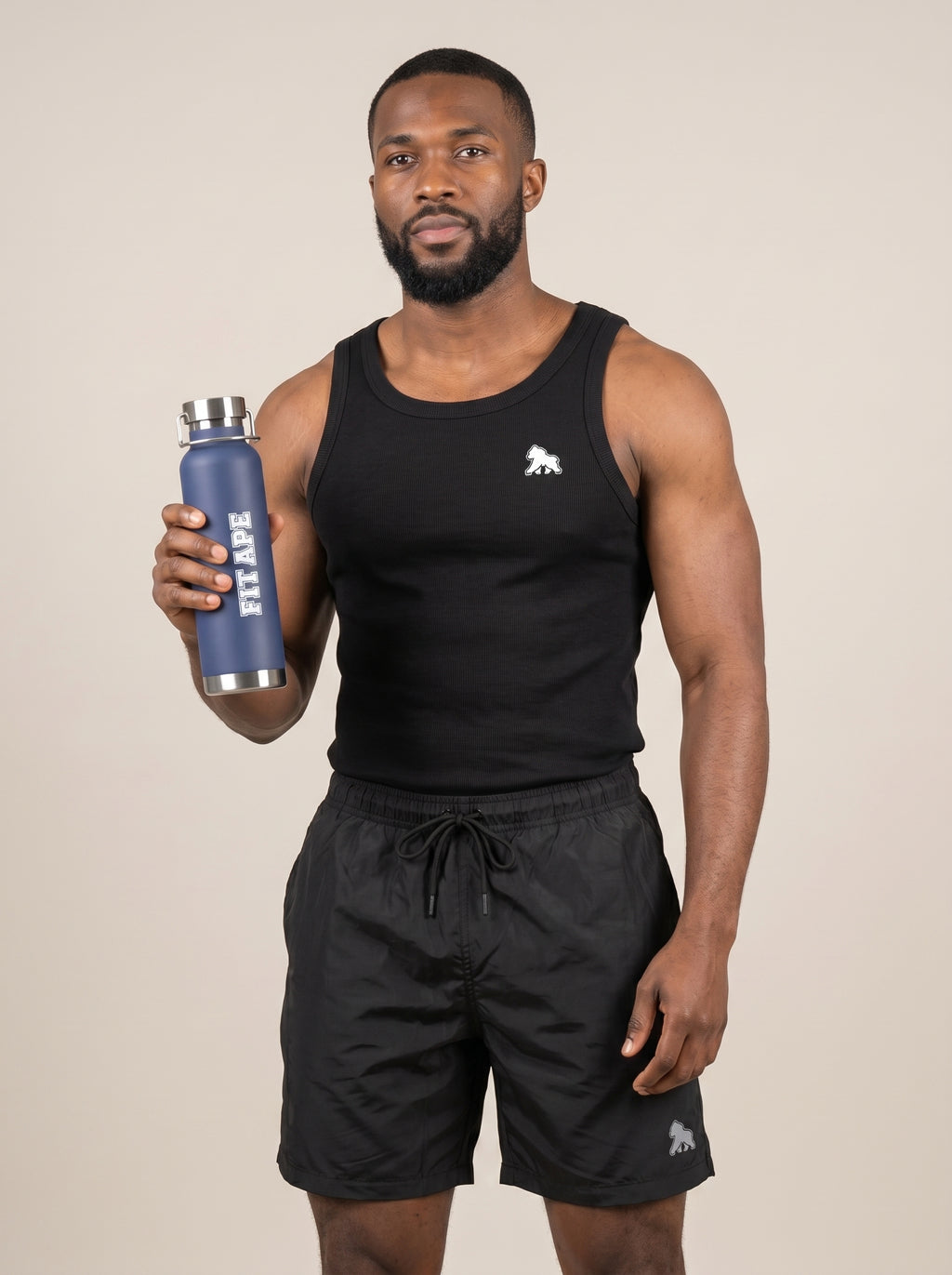 Model in black gym clothing holding up a navy FIT APE water bottle