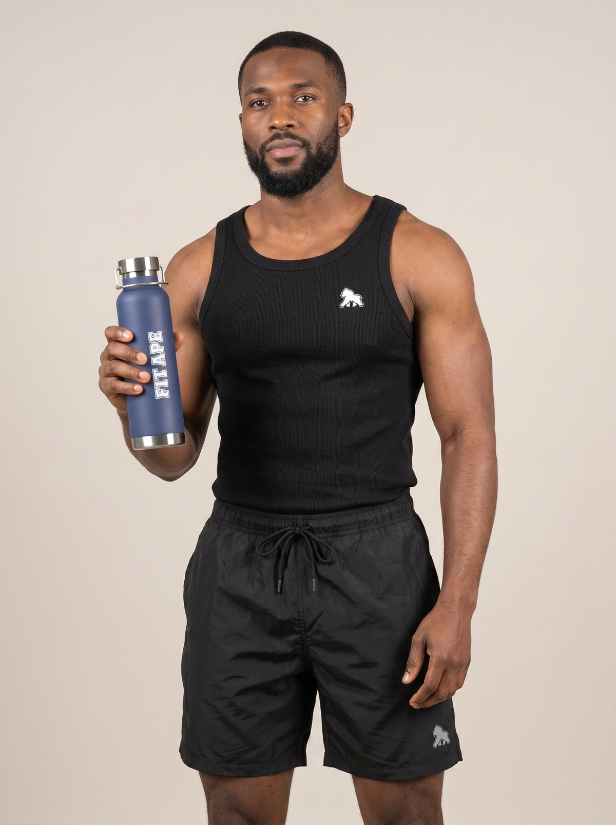 Model in black gym clothing holding up a navy FIT APE water bottle