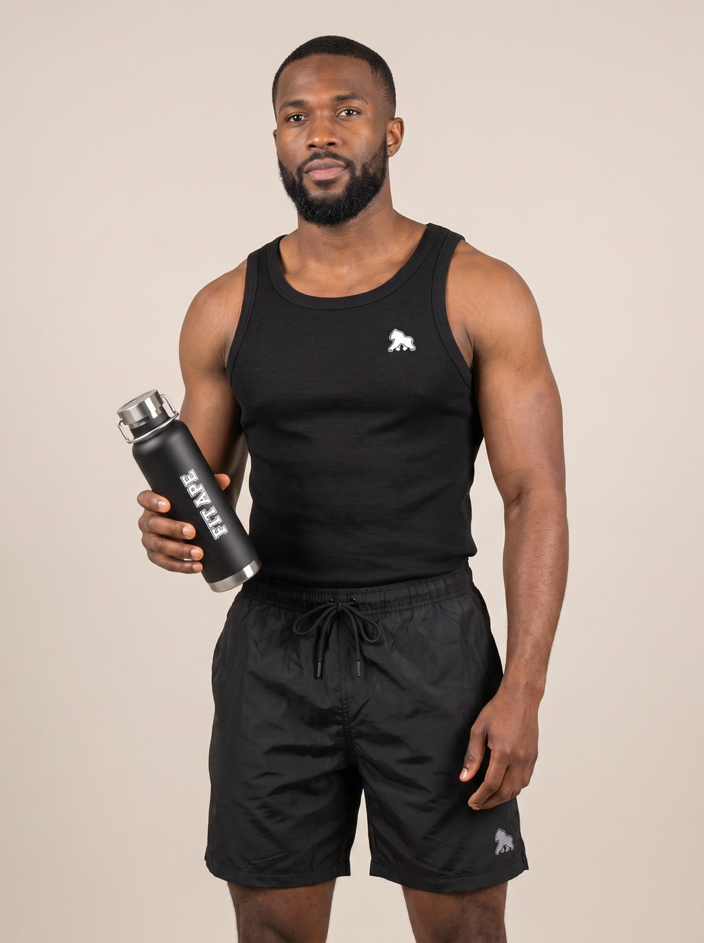 Model in black gym clothing presenting a black FIT APE water bottle