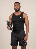 Model in black gym clothing presenting a black FIT APE water bottle