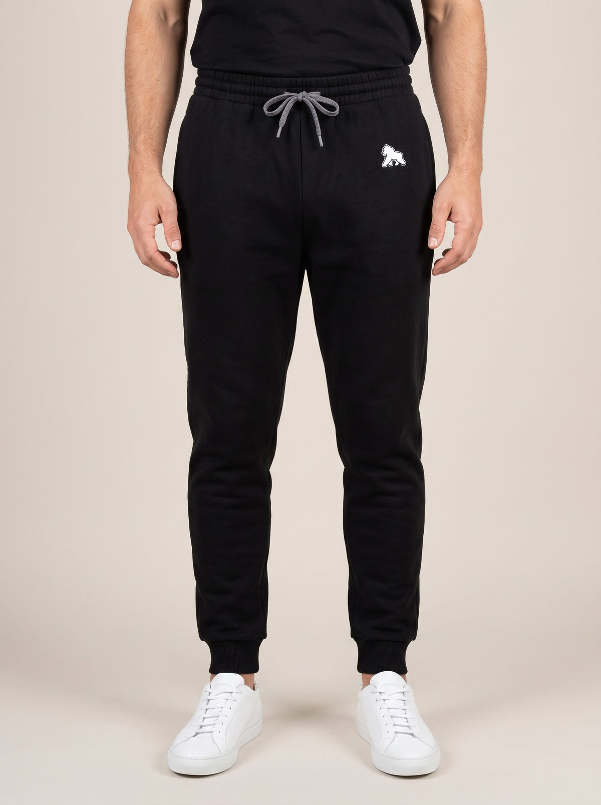 Black FIT APE men's drawstring joggers with white hip gorilla, front view