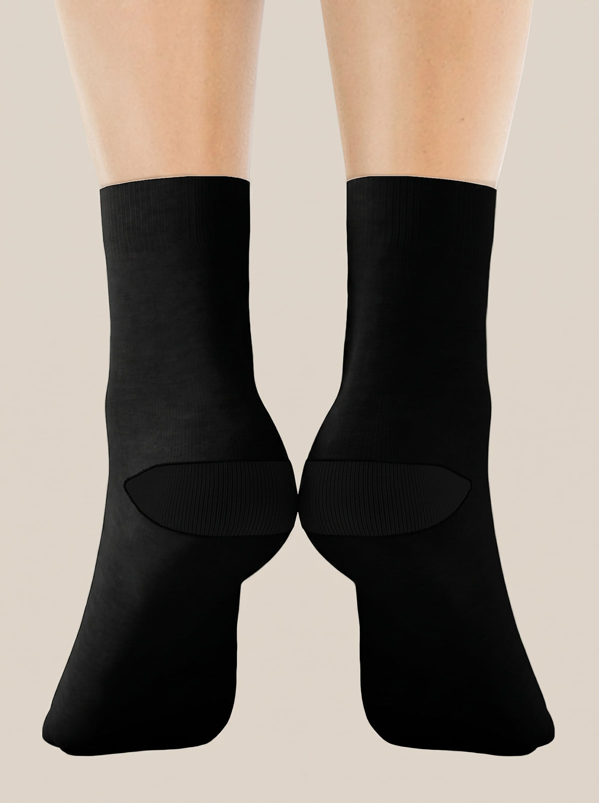 Black FIT APE crew socks worn on feet, rear view showing heels and soles