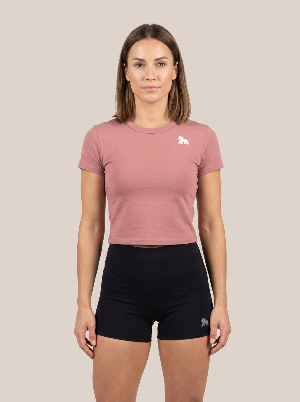 Pink FIT APE women's cropped performance top on a model, front view