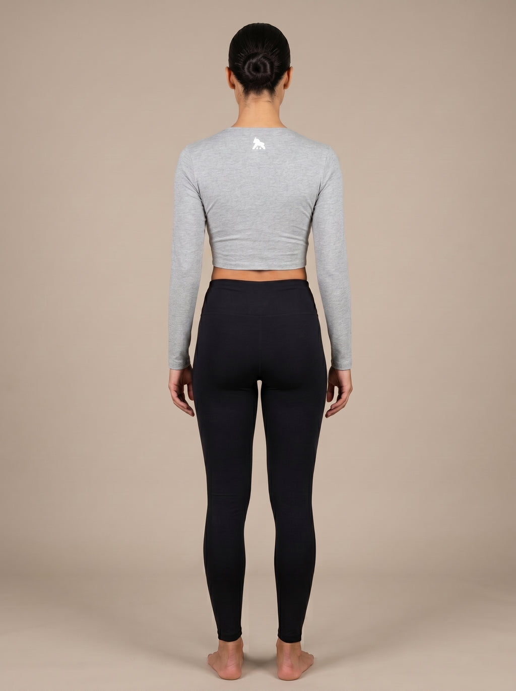 Gray FIT APE women's long-sleeve compression crop top on a model, back view