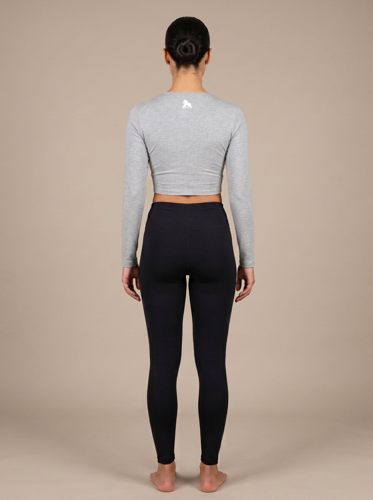 Gray FIT APE women's long-sleeve compression crop top on a model, back view