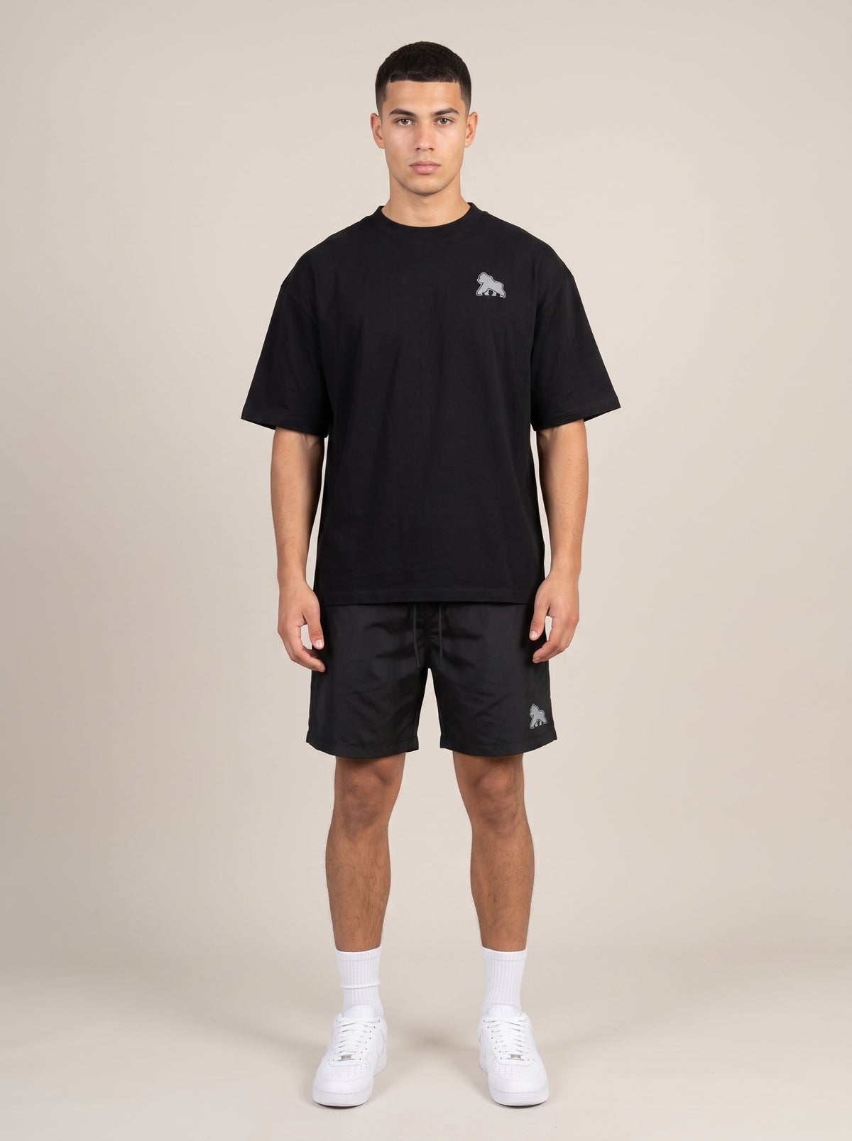 Full-length model wearing a black FIT APE men's oversized tee