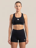 Model wearing a black FIT APE sports bra with white chest gorilla, front view