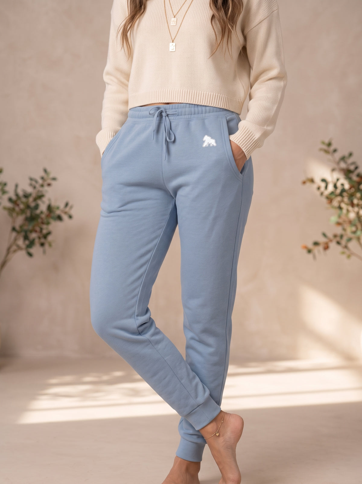 Model wearing light blue FIT APE women's sweatpants with a cream top