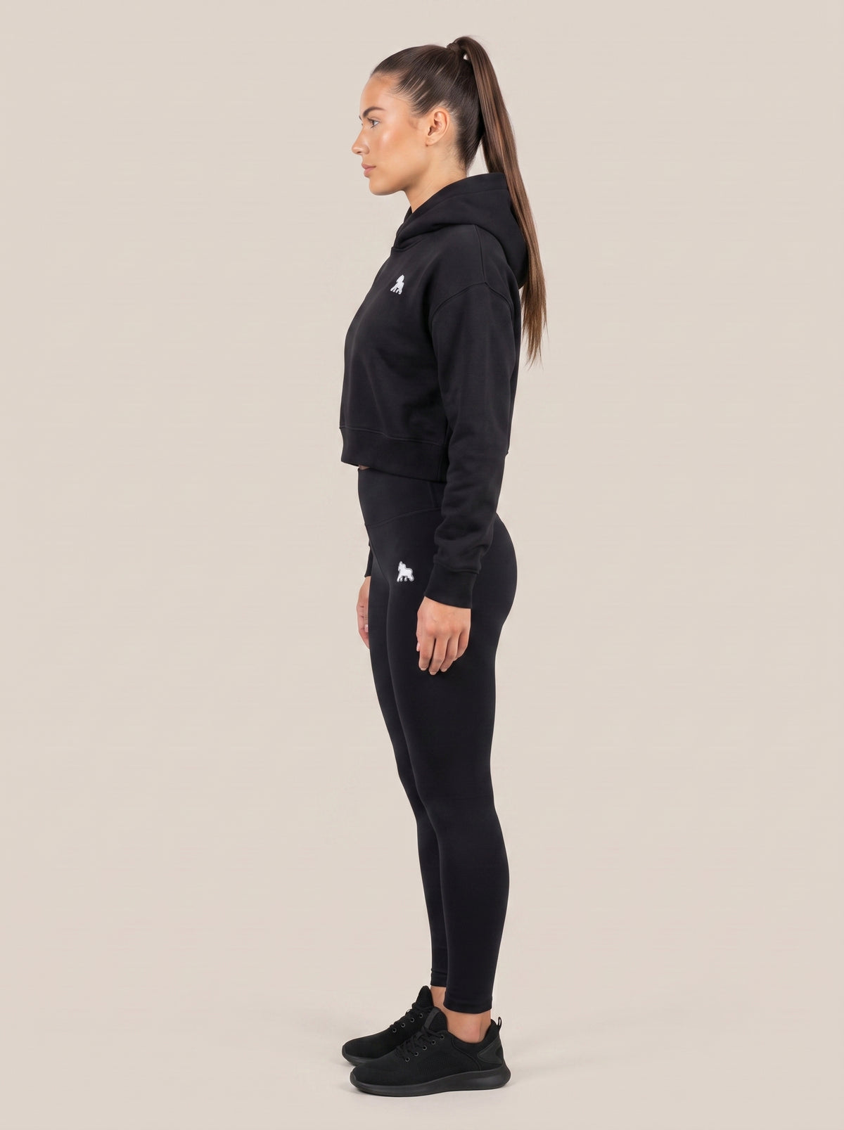 Black FIT APE women's cropped hoodie on a model, side view