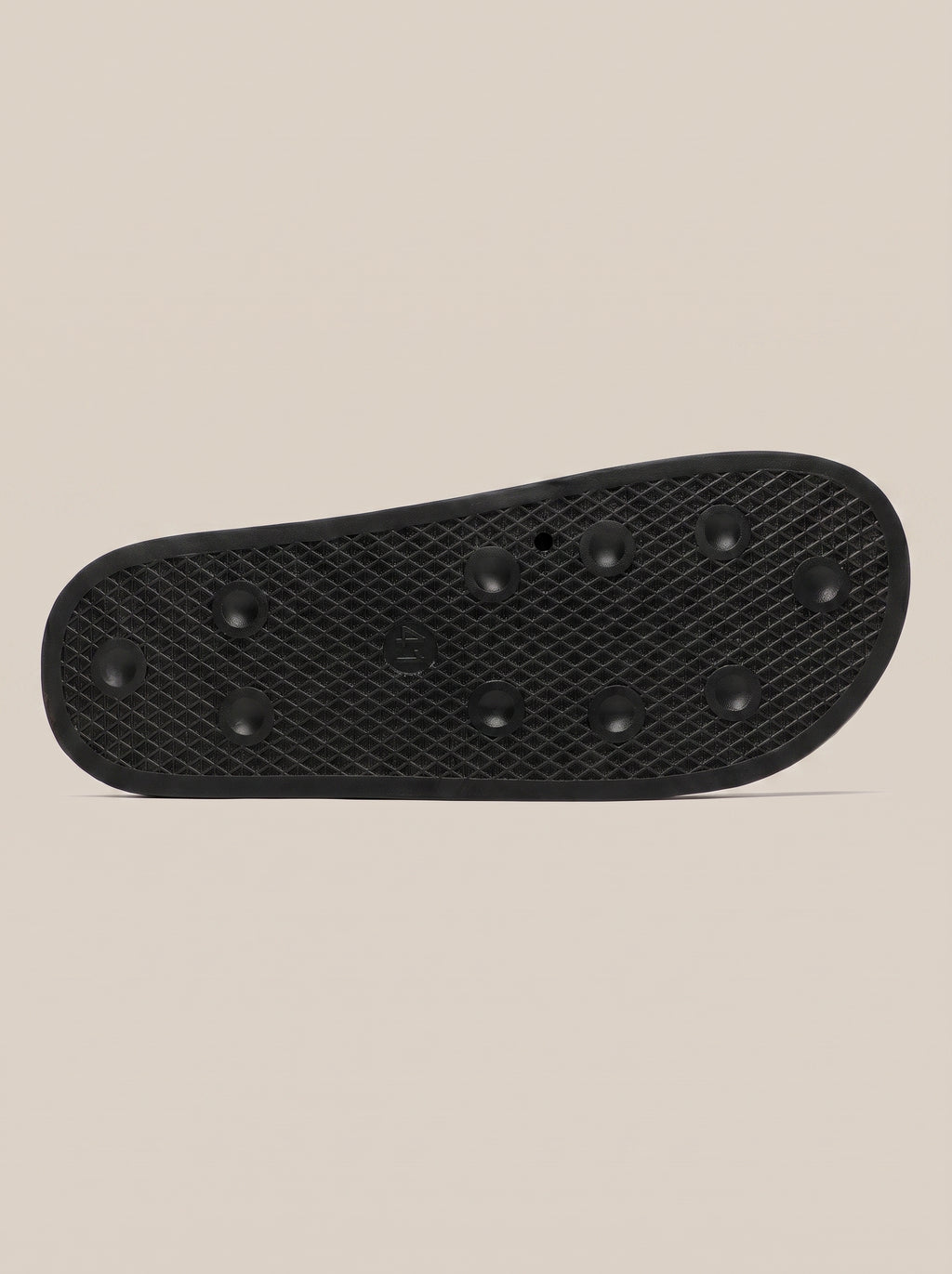 Textured black outsole of a women's FIT APE slide