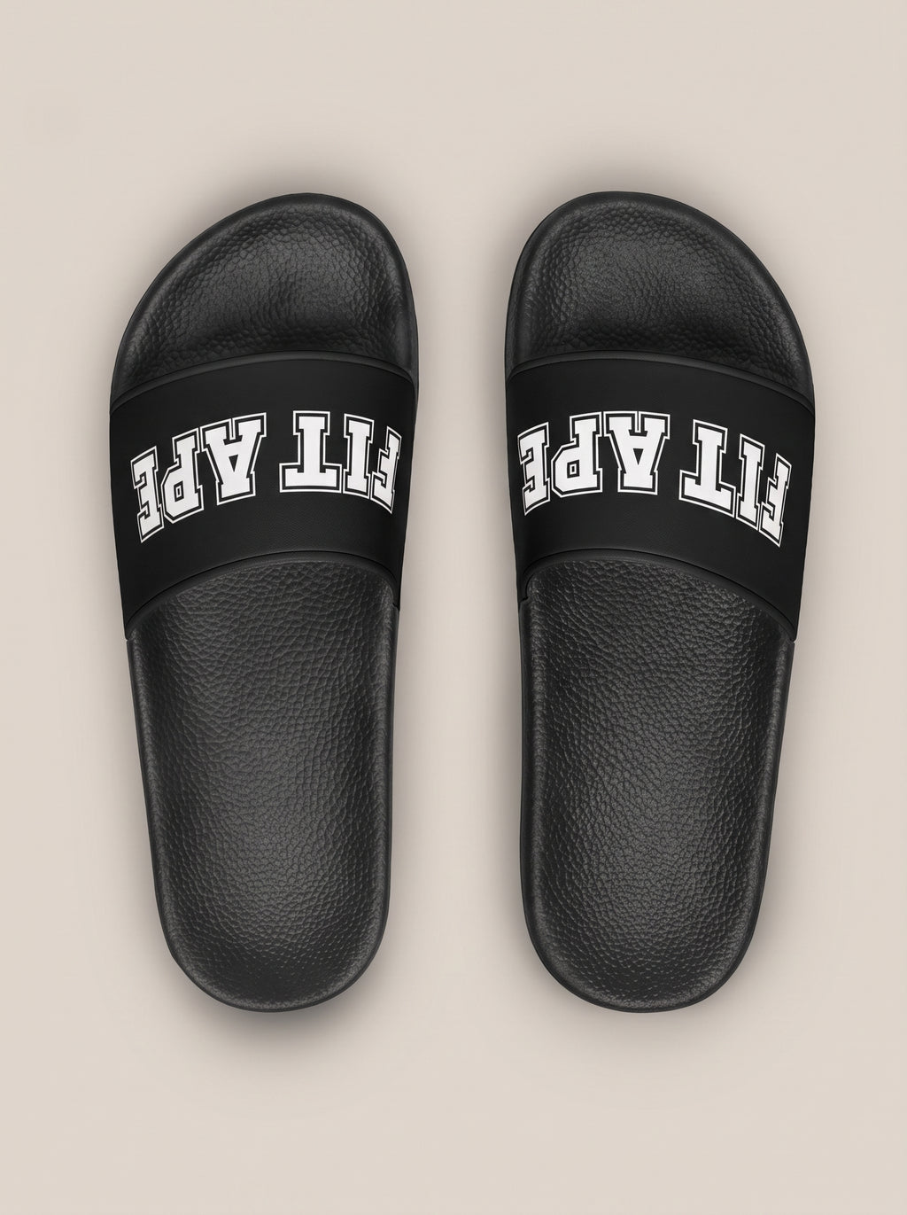 Pair of black women's FIT APE slides with toes pointing away, top view