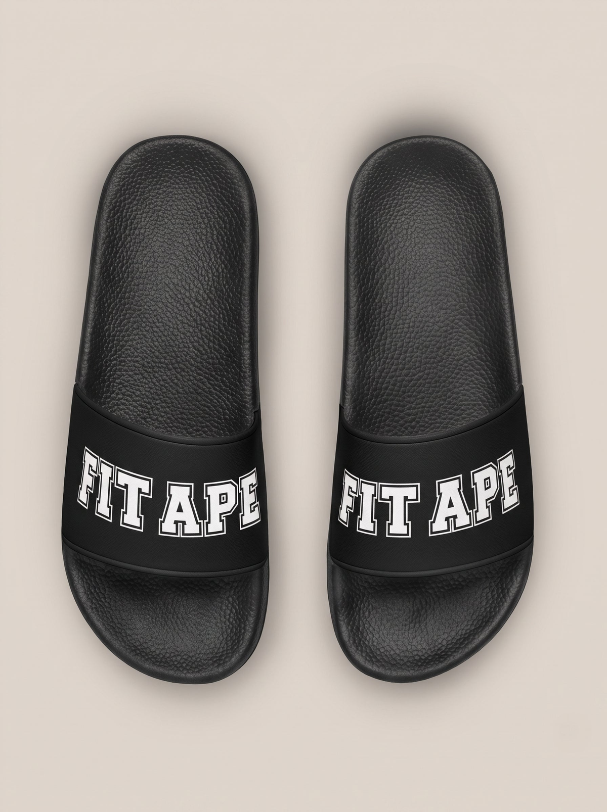 Pair of black women's FIT APE slides with white lettering, top view